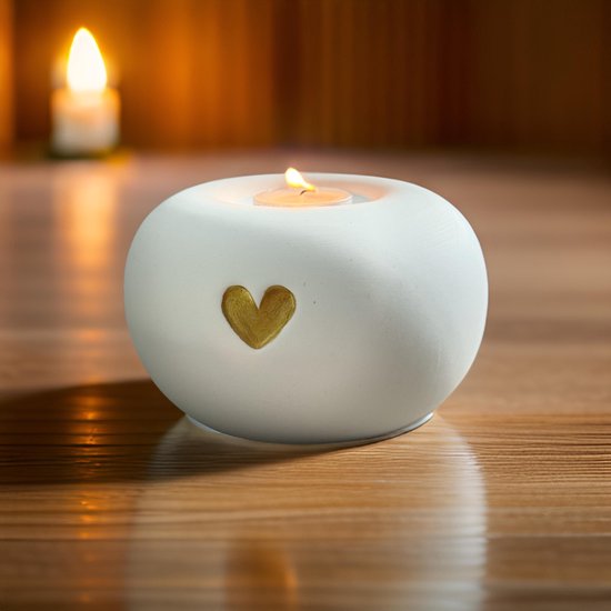 Witte keramieken mini-urn met gouden hartje en een brandend theelichtje